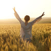 Woman-Raising-Hands-in-Field-with-Energy-and Joy
